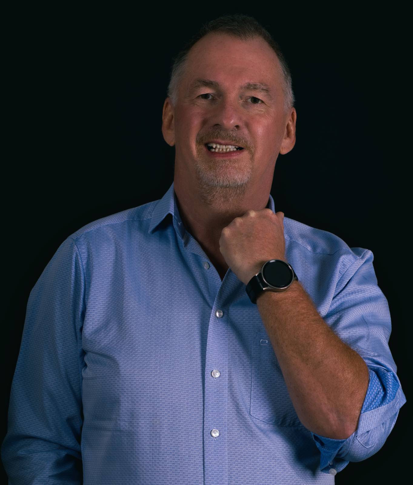Natürliches Studio Portrait von Uwe im blauen Hemd vor dunklem Hintergrund